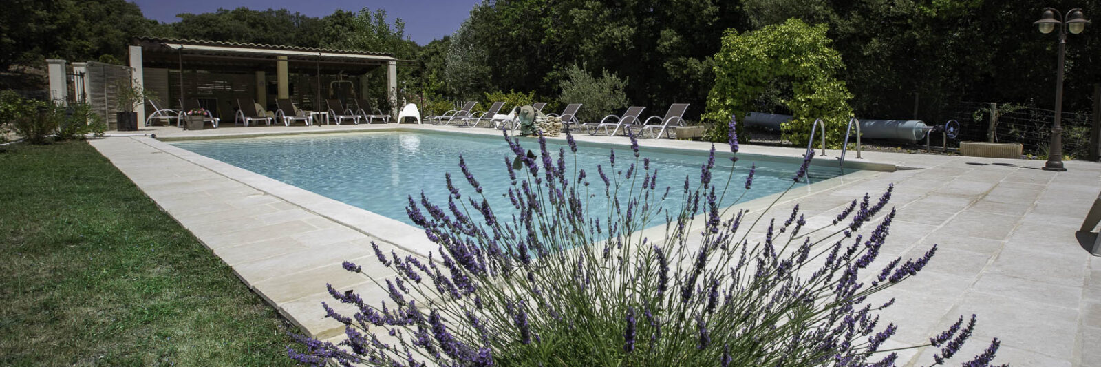 Grande piscine au sel 13×6 m du Mas Saint Antoine, chaises longues et coin salon ombragé, idéale pour des vacances en famille en Ardèche