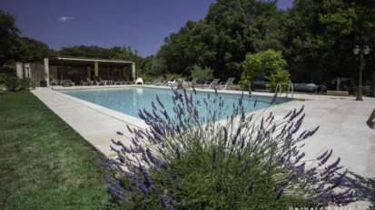 Grande piscine au sel 13×6 m du Mas Saint Antoine, chaises longues et coin salon ombragé, idéale pour des vacances en famille en Ardèche