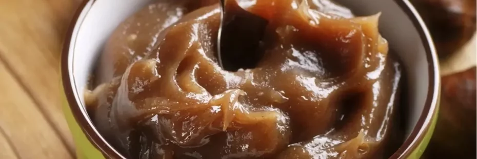 Pot de crème de marrons de l'Ardèche ouvert, avec des châtaignes, sur une table en bois