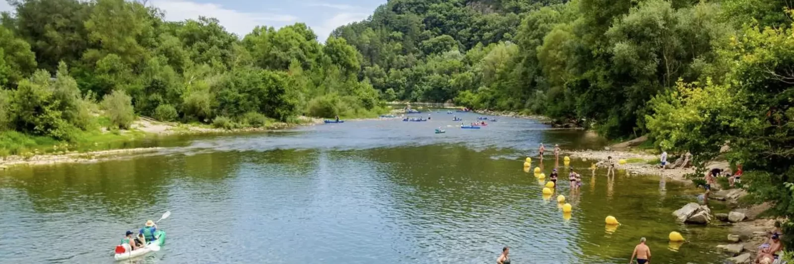 Baignade dans la rivière Ardèche à Saint-Martin-d'Ardèche, eau turquoise et village d'Aiguèze en fond