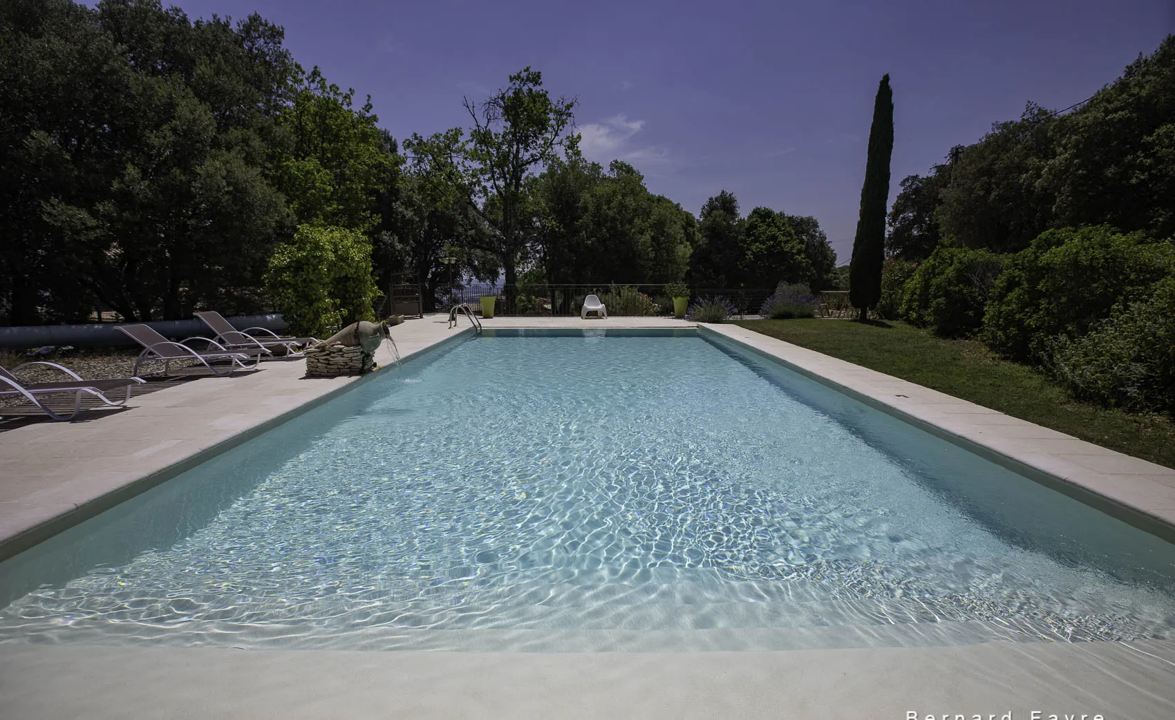 Piscine au sel 13 × 6 m du Mas Saint Antoine bordée de cyprès et d'oliviers, en Ardèche méridionale