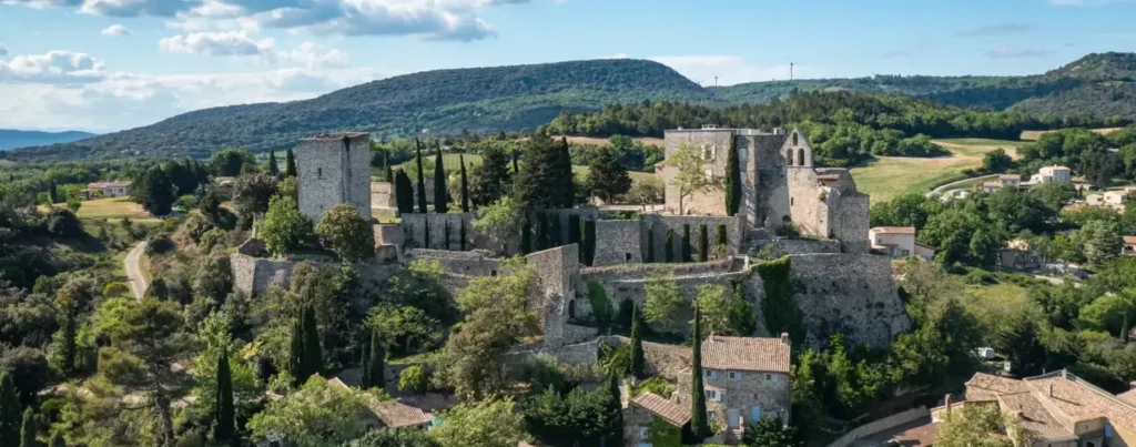Enfant en baudrier sur un parcours d'accrobranche dans les arbres de Vert'tige Aventure à Roussas, Drôme provençale