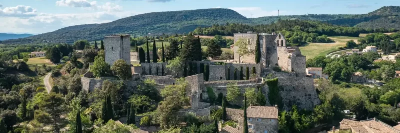 Enfant en baudrier sur un parcours d'accrobranche dans les arbres de Vert'tige Aventure à Roussas, Drôme provençale